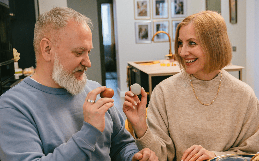 A couple holding eggs and smiling at each other during Easter