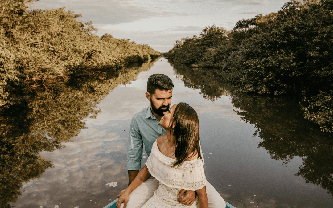 A couple in love sat together in a boat on water, love languages of quality time and physical touch